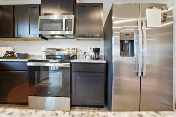 a large kitchen with granite countertop a large counter top cabinets appliances and a sink