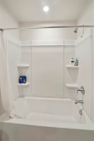 a bedroom with a bed a computer on a desk and a window