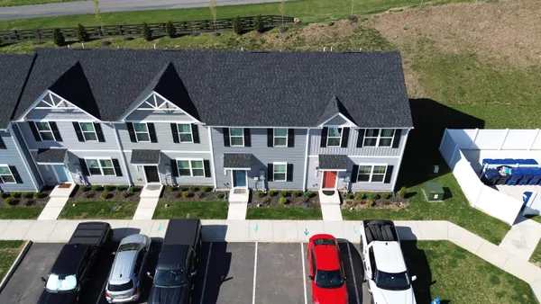 an aerial view of residential houses with outdoor space and parking