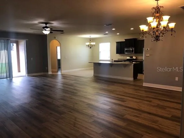 a view of a living room with kitchen view and wooden floor