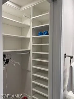 a view of walk in closet with empty racks