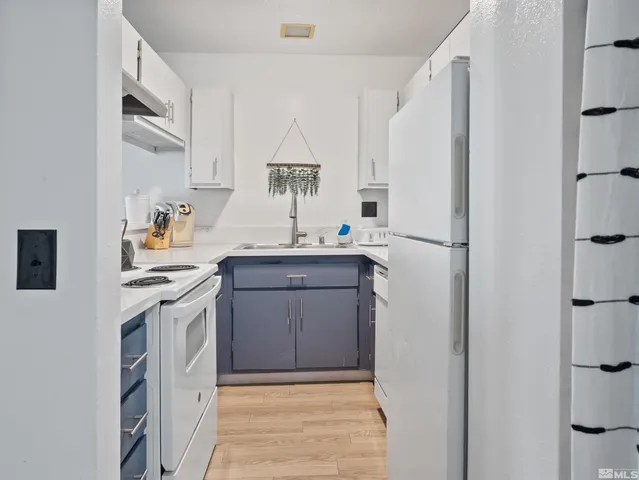 a kitchen with stainless steel appliances a refrigerator sink and white cabinets