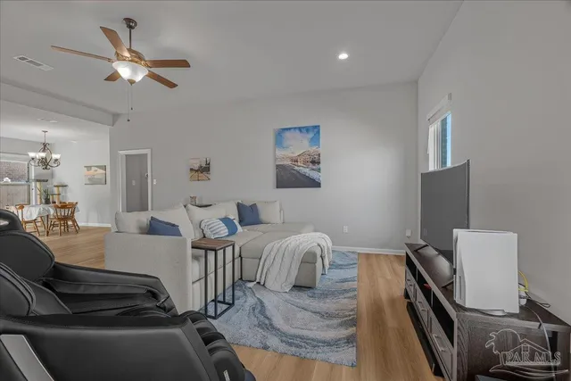 a living room with furniture and a dining table with kitchen view