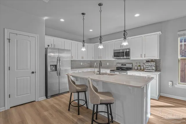 a kitchen with granite countertop white cabinets and stainless steel appliances