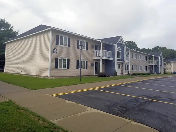 a view of a big house with a big yard and large trees