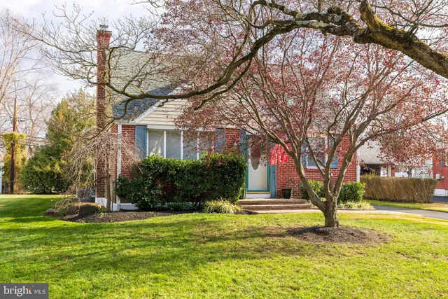 a view of a house with a yard and large tree