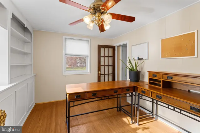 a room with chandelier fan and wooden floor