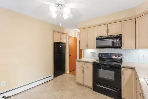 a kitchen with stainless steel appliances a stove a microwave and white cabinets