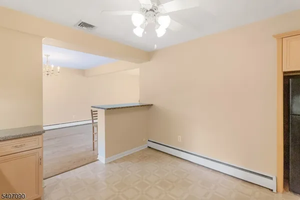 an empty room with a ceiling fan and hallway
