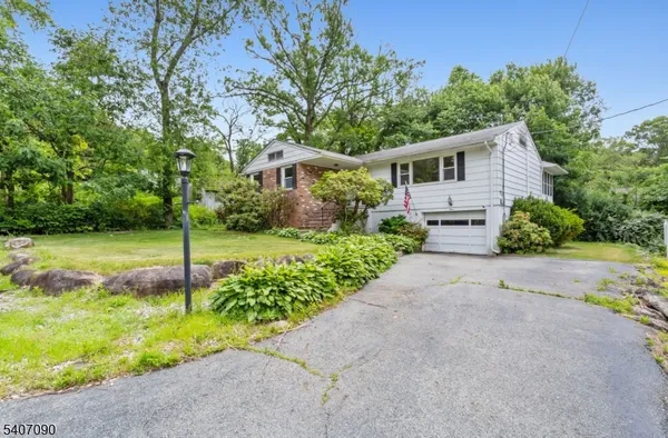 a front view of a house with a yard and an tree