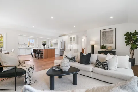 a living room with furniture and view of kitchen
