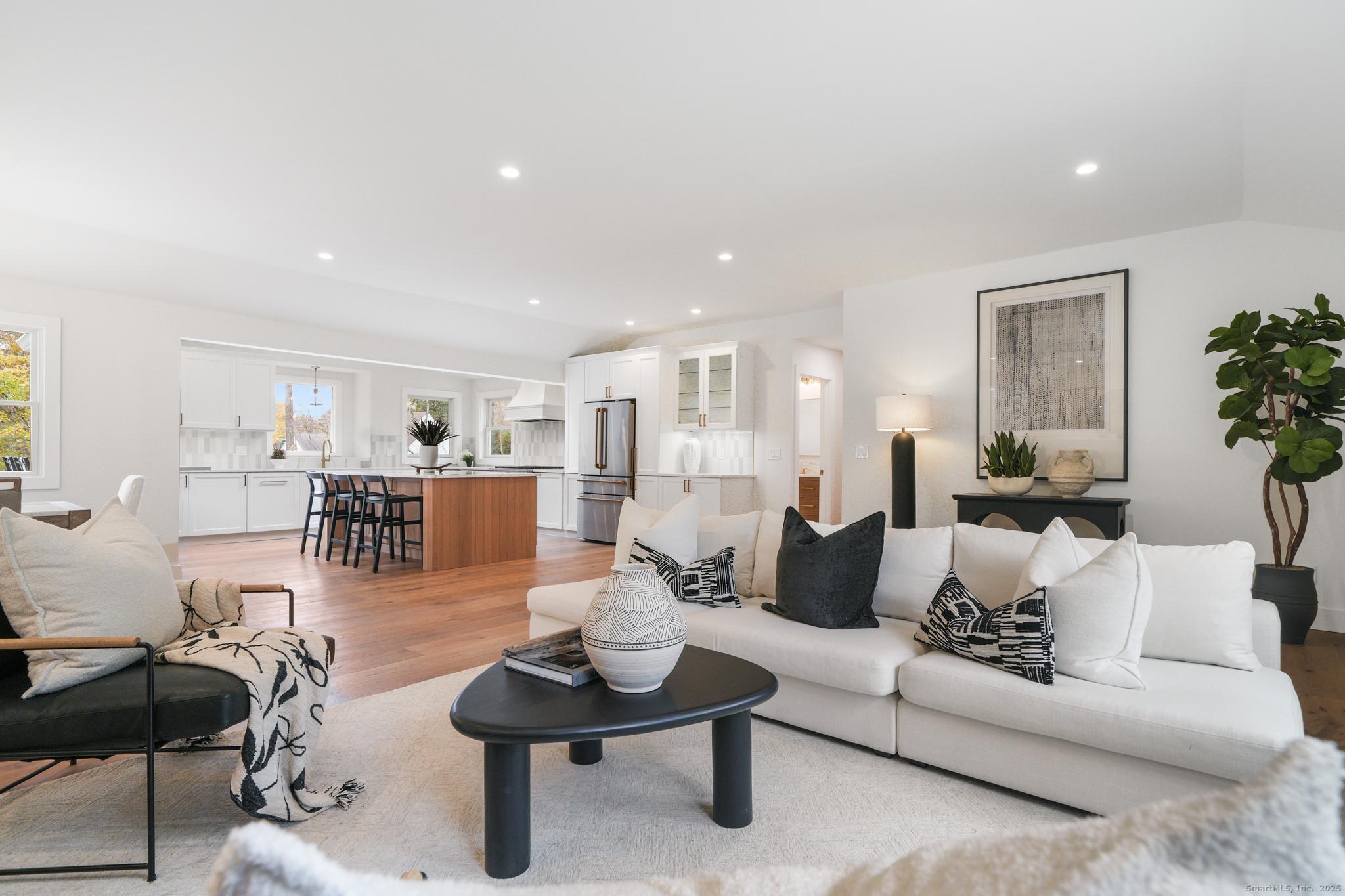 a living room with furniture and view of kitchen