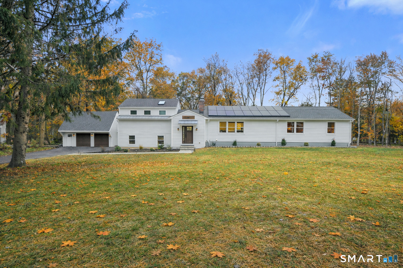 a front view of a house with a large trees