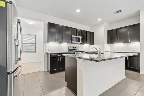 a kitchen with stainless steel appliances granite countertop a sink stove and refrigerator