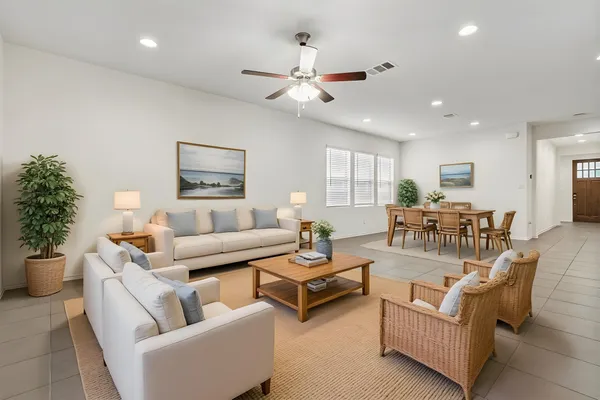 a living room with furniture kitchen view and a chandelier
