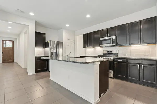 a kitchen with kitchen island granite countertop stainless steel appliances and cabinets