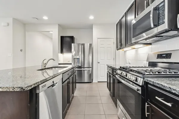 a kitchen with stainless steel appliances granite countertop a stove sink and cabinets