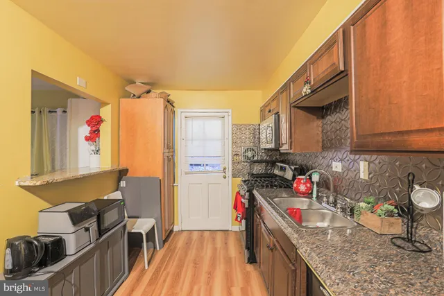 a kitchen that has a lot of cabinets and wooden floor