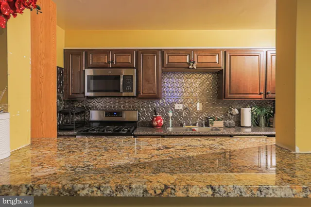 a kitchen with stainless steel appliances granite countertop a stove top oven microwave and cabinets