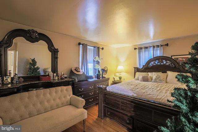 a bedroom with a bed a dresser and potted plants