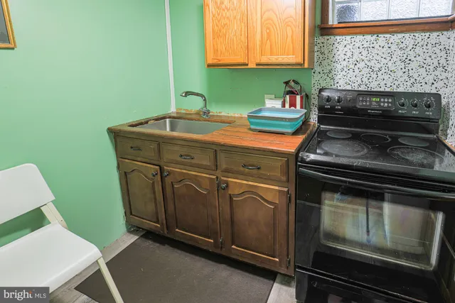a kitchen with granite countertop a sink cabinets and stainless steel appliances