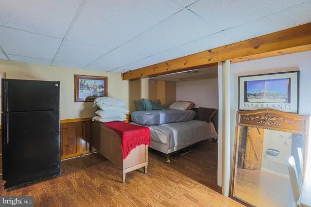 a living room with furniture and a refrigerator