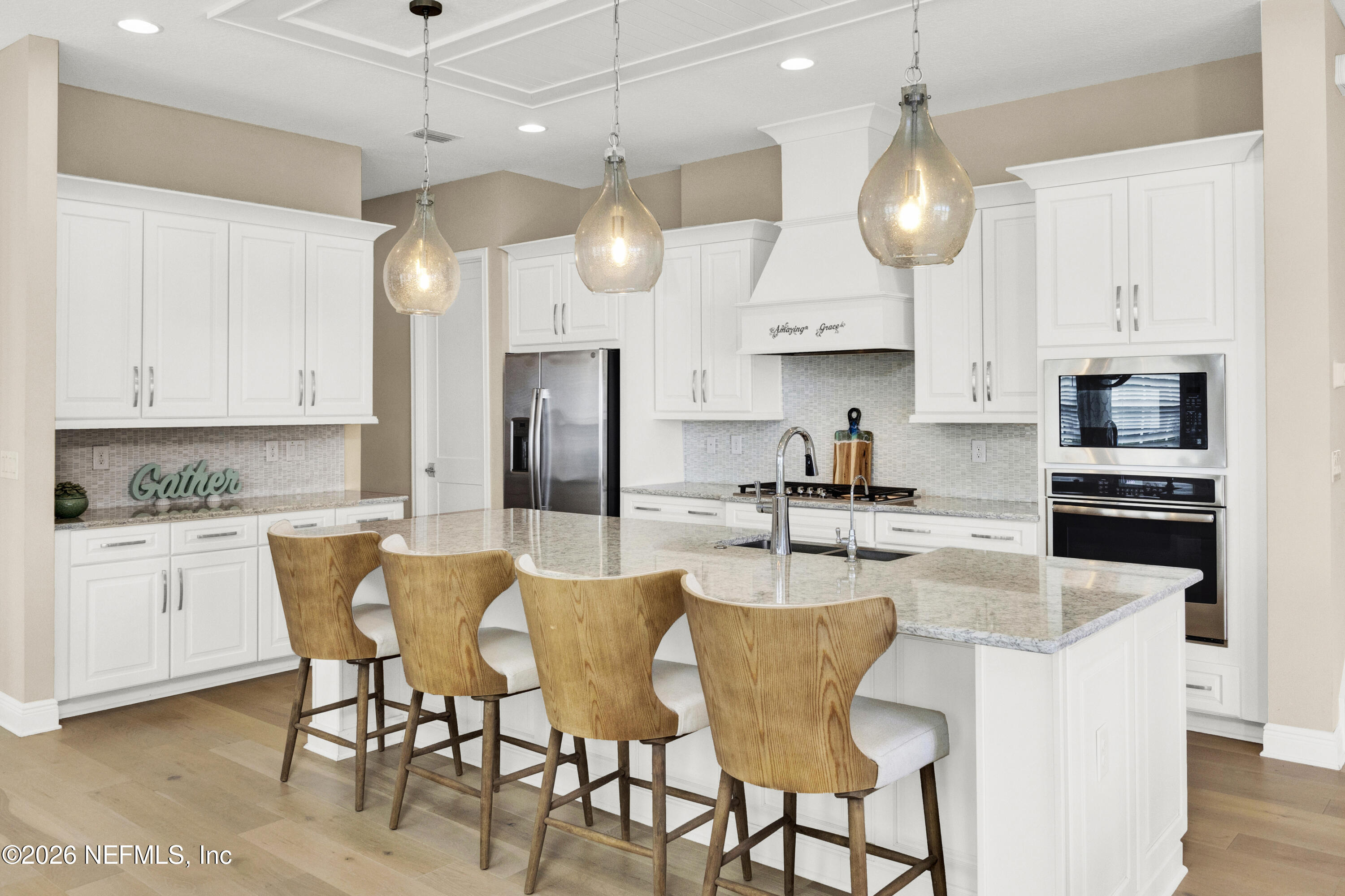 247 Rum Runner Way St. Johns, FL 32259 - Photo 10 of 42 a kitchen with stainless steel appliances granite countertop a stove a sink a refrigerator a center island a table and chairs