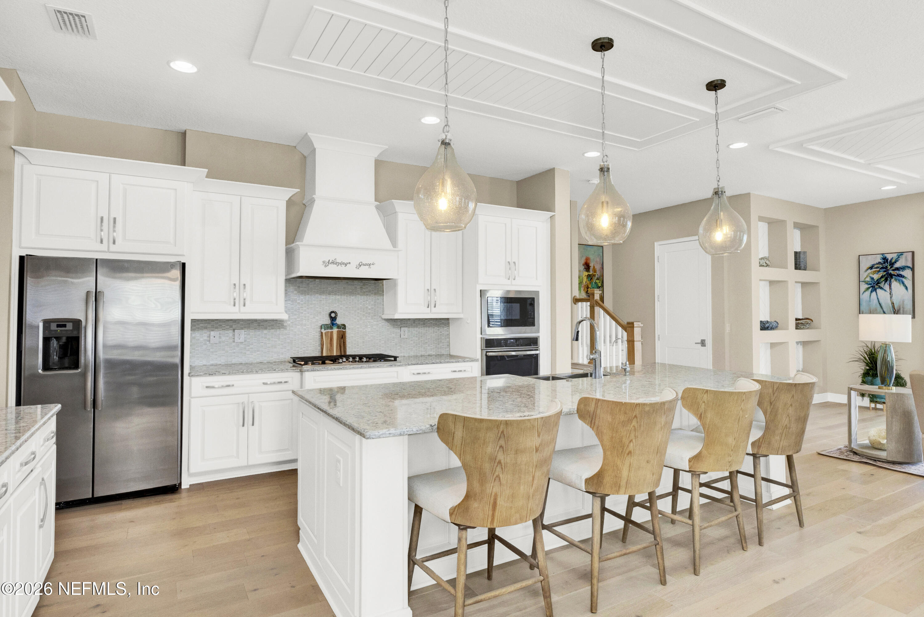 247 Rum Runner Way St. Johns, FL 32259 - Photo 8 of 42 a kitchen with stainless steel appliances kitchen island granite countertop a table chairs refrigerator and microwave