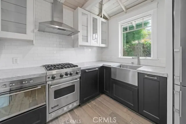 a kitchen with stainless steel appliances white cabinets and a stove top oven