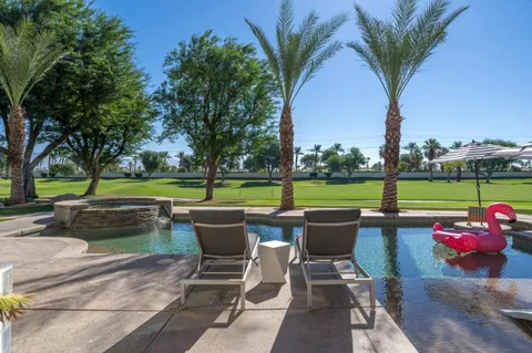 a view of a patio with couches table and chairs potted plants and palm tree