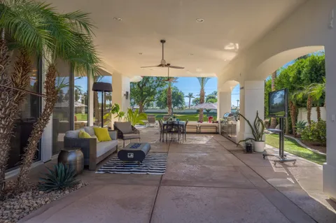a view of a patio with table and chairs potted plants and palm tree