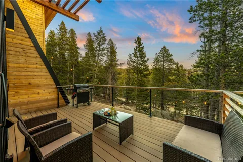 a view of a balcony with wooden floor and outdoor seating