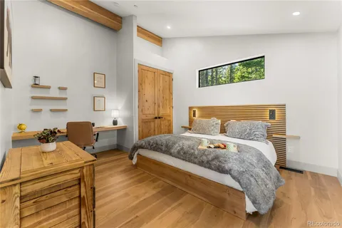 a bedroom with a bed and wooden floor