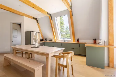 a dining room with a table chairs and a kitchen