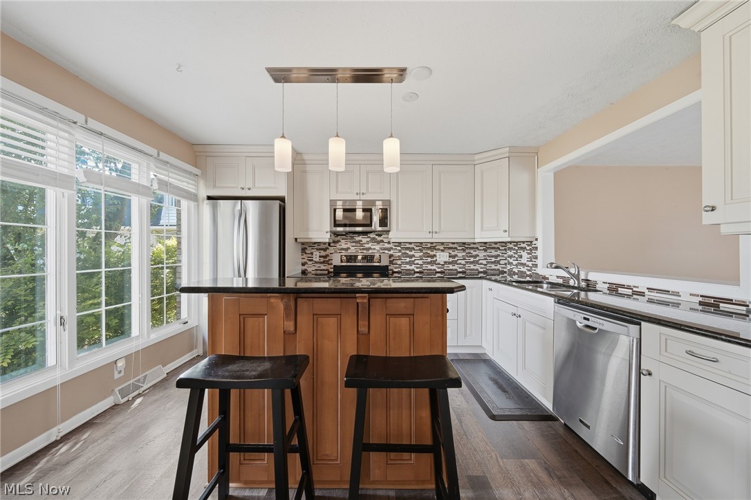 824 South Chillicothe Road, Unit 2 Aurora, OH 44202 - Photo 2 of 42 Contemporary kitchen featuring white cabinetry, dark countertops, and a mosaic tile backsplash