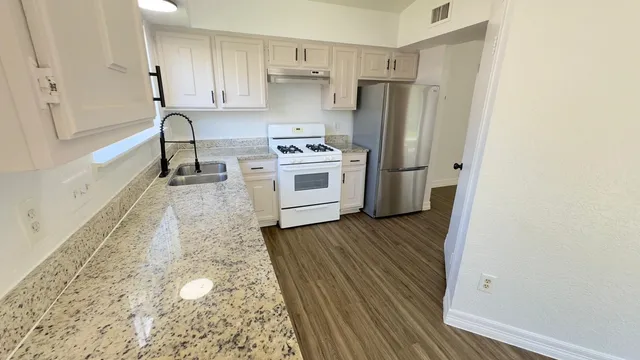 a kitchen with stainless steel appliances a refrigerator and a stove top oven