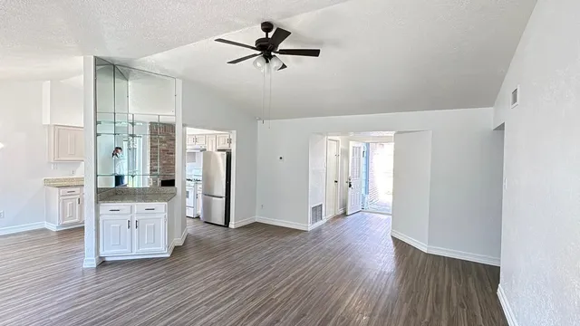 a view of a kitchen with wooden floor and a ceiling fan
