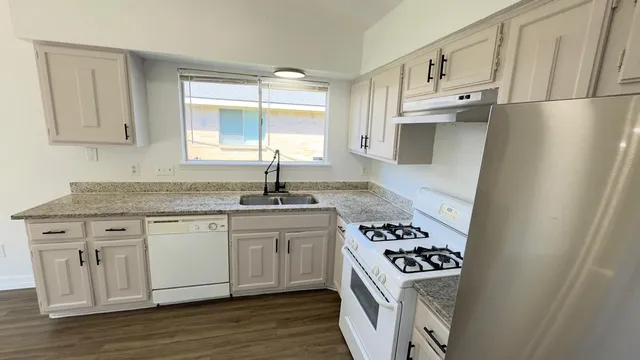 a kitchen with stainless steel appliances granite countertop a sink stove and refrigerator