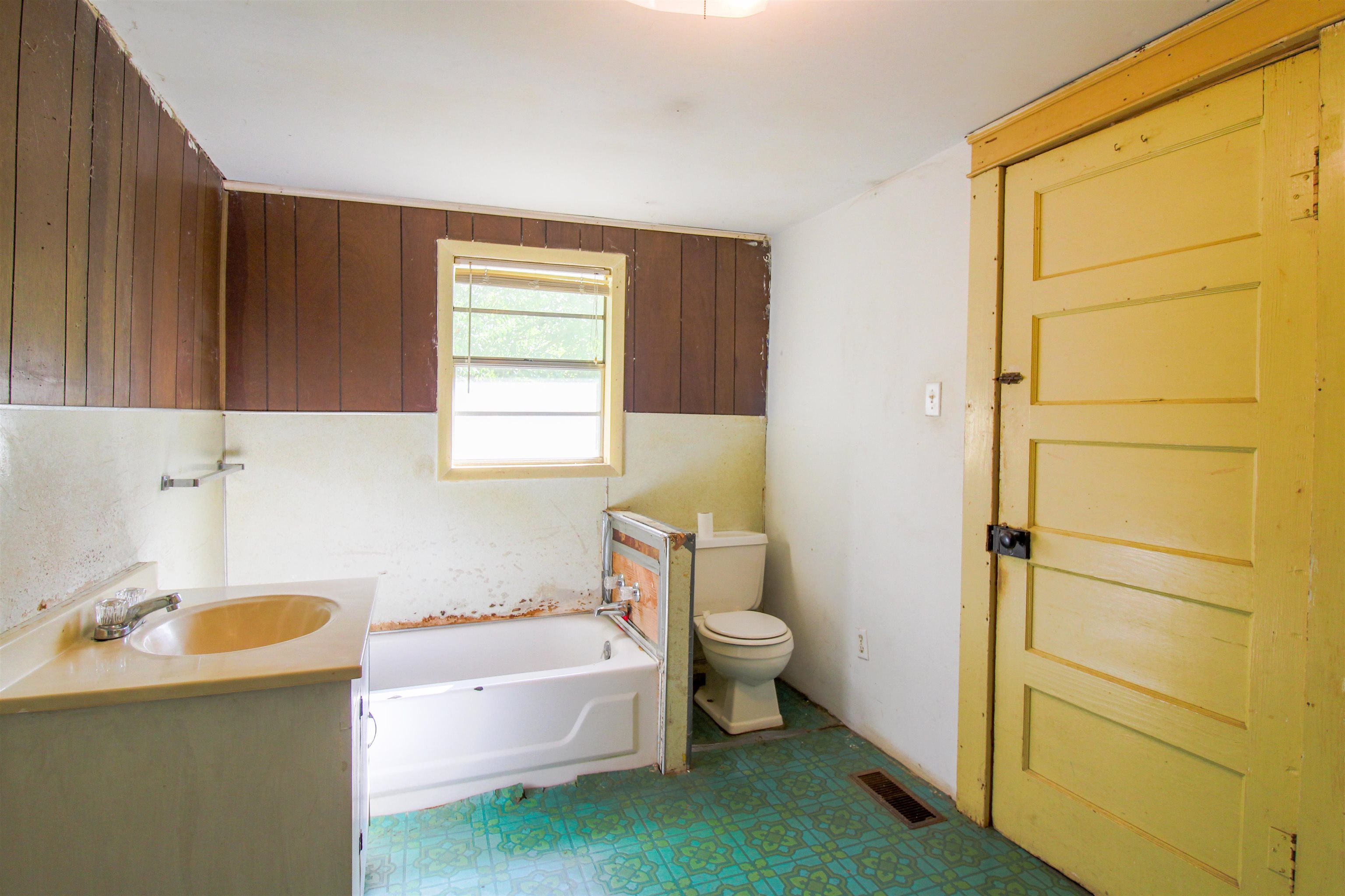 2440 Edith-Nankipoo Road Ripley, TN 38063 - Photo 16 of 27 Bathroom with a bath, vanity, dark flooring, and wood walls