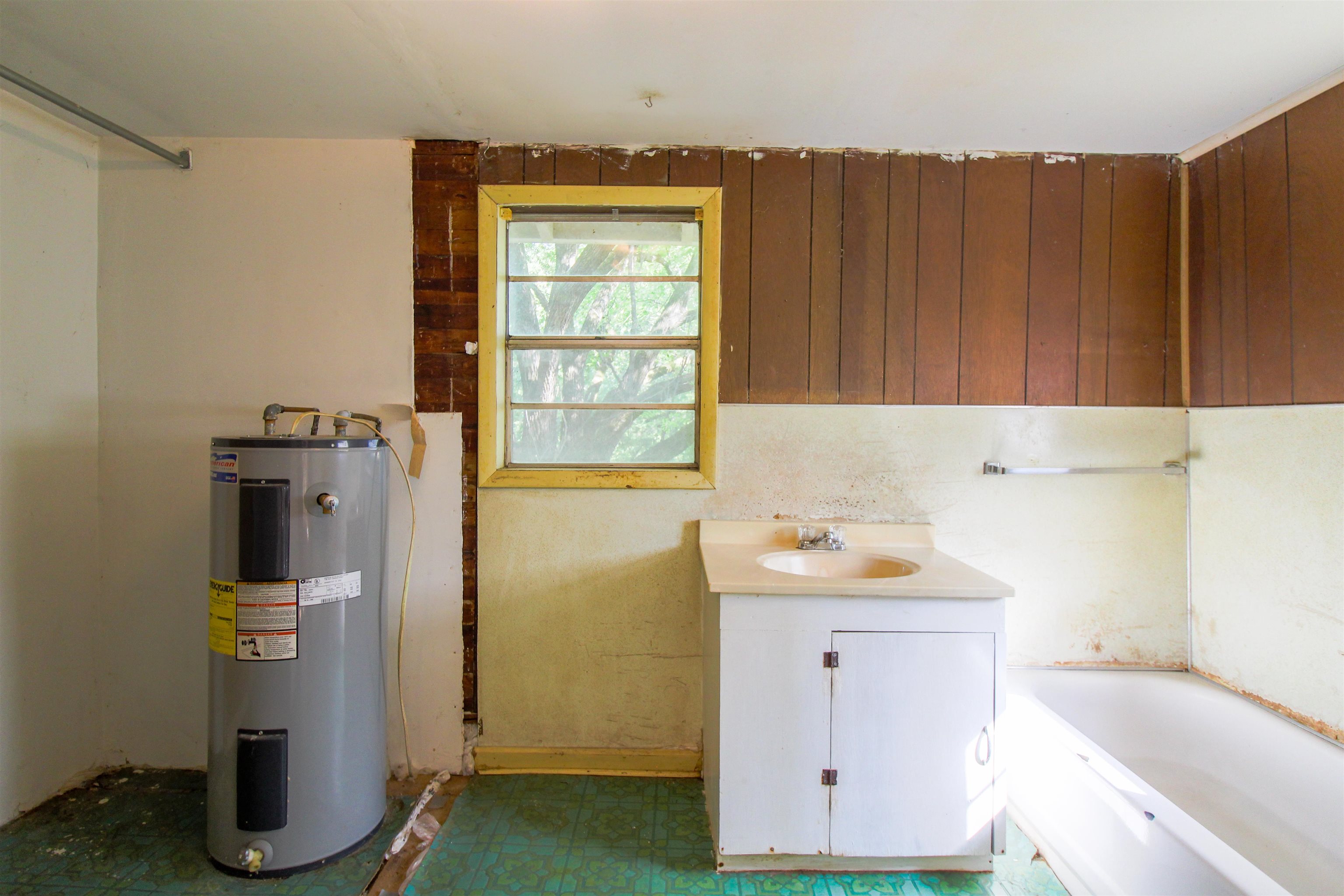 2440 Edith-Nankipoo Road Ripley, TN 38063 - Photo 17 of 27 Bathroom with a bath, electric water heater, dark floors, and vanity