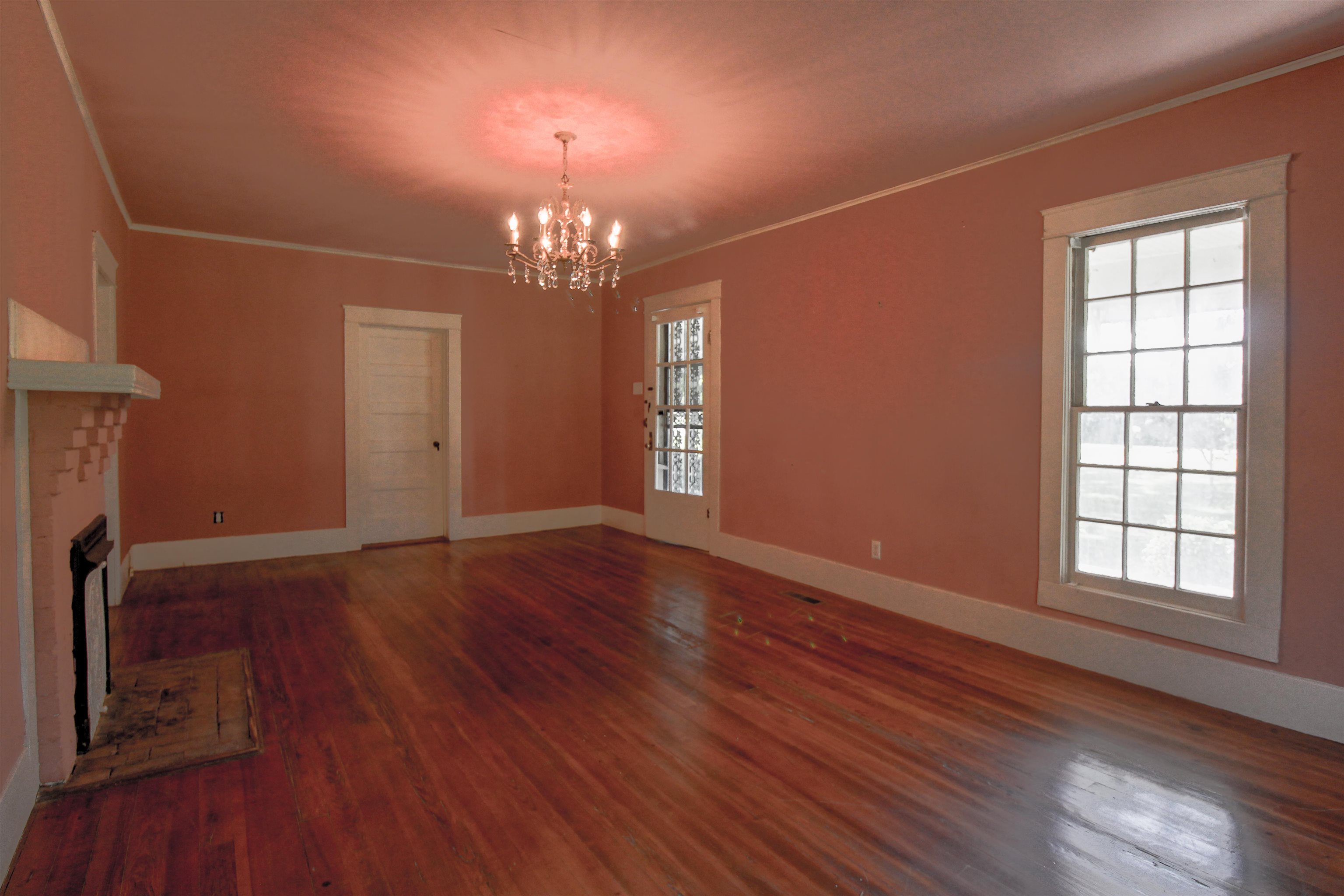 2440 Edith-Nankipoo Road Ripley, TN 38063 - Photo 2 of 27 Living room featuring ornamental molding, a brick fireplace, original hardwood floors , and a chandelier