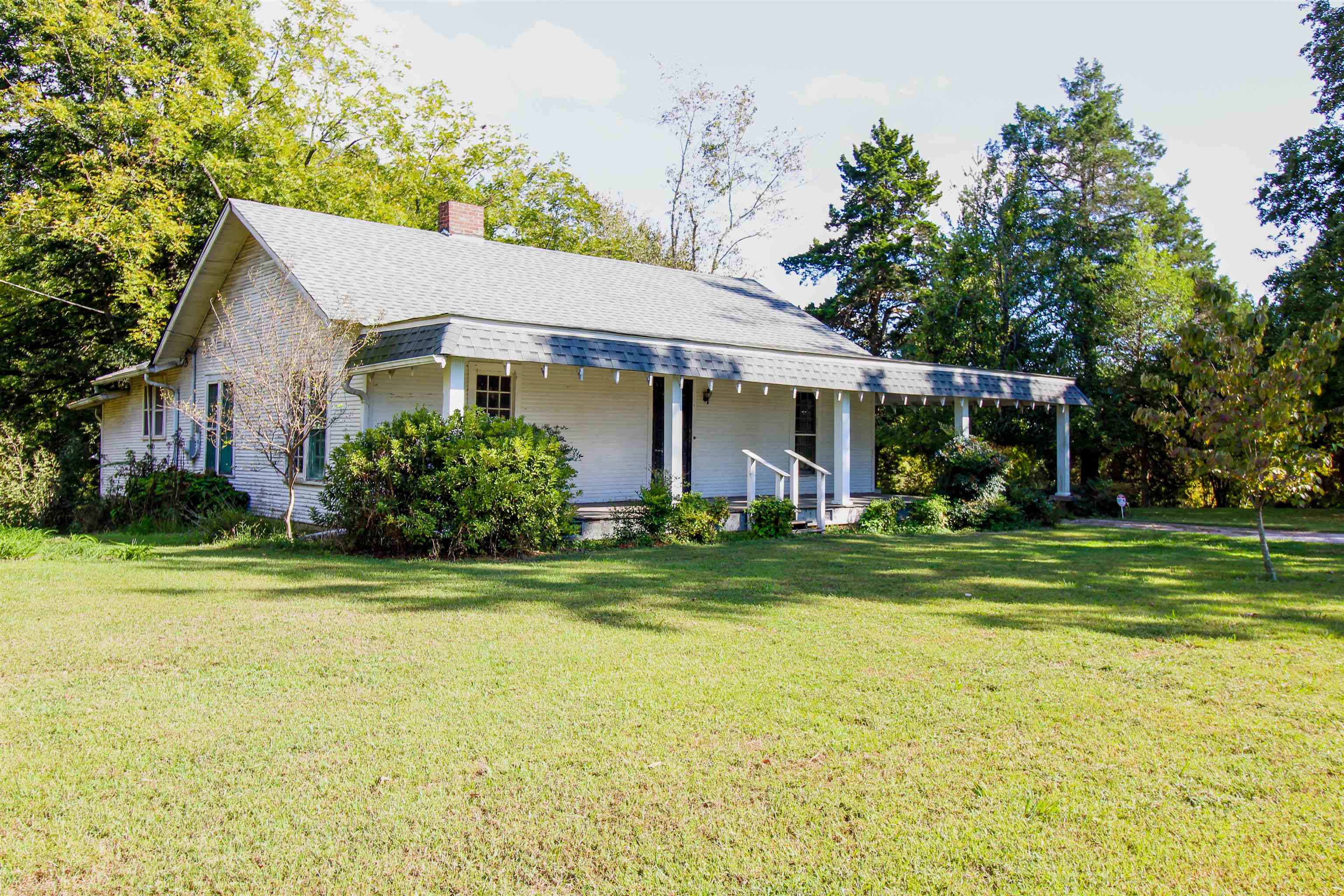 2440 Edith-Nankipoo Road Ripley, TN 38063 - Photo 22 of 27 View of side of property featuring covered porch, a chimney, a lawn, and a shingled roof