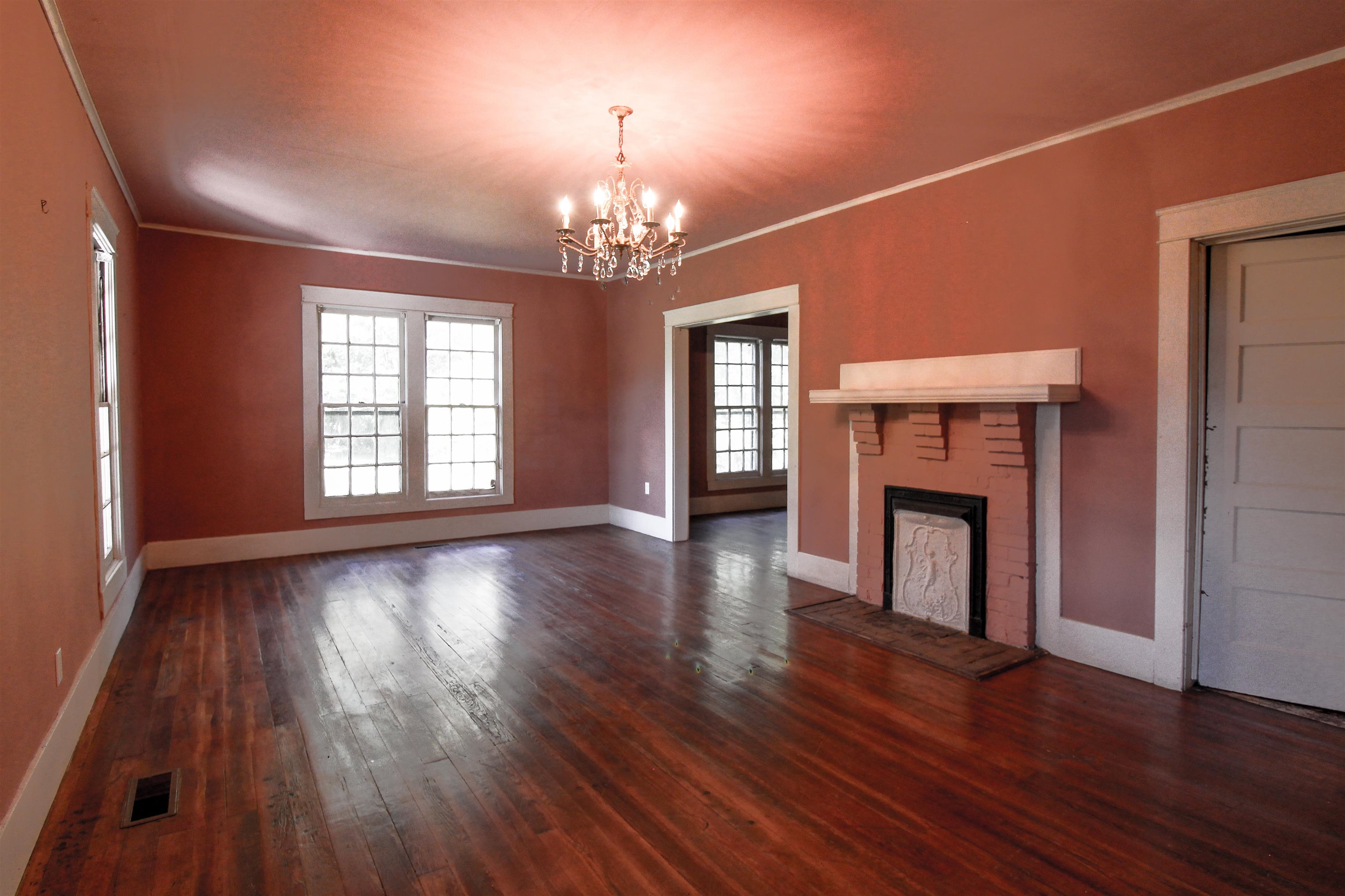 2440 Edith-Nankipoo Road Ripley, TN 38063 - Photo 3 of 27 Living room featuring ornamental molding, a brick fireplace, original hardwood floors , and a chandelier and crown molding.