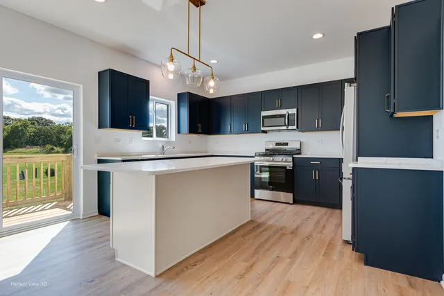 a kitchen with stainless steel appliances granite countertop a refrigerator a sink dishwasher a stove and white countertops with wooden floor