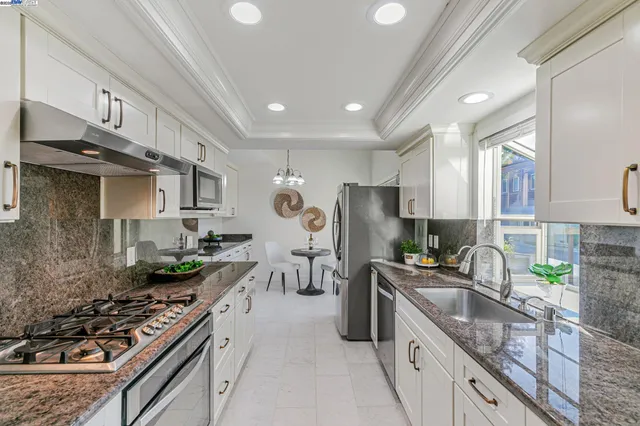 a kitchen with stainless steel appliances granite countertop a sink stove and refrigerator