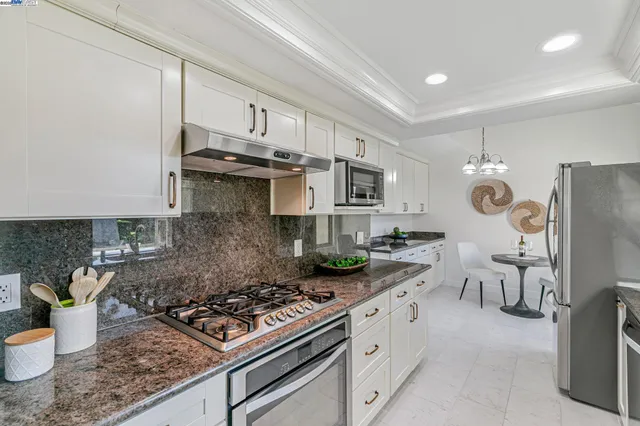 a kitchen with stainless steel appliances granite countertop a sink stove and refrigerator