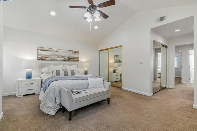 a spacious bedroom with two beds and a chandelier
