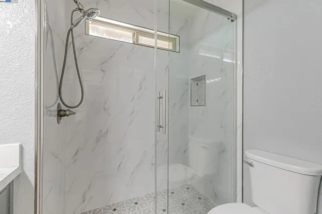 a bathroom with a toilet a sink and mirror