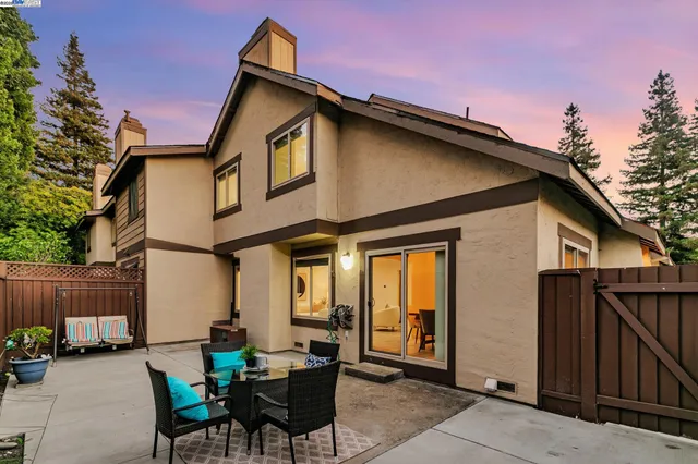 a backyard of a house with table and chairs
