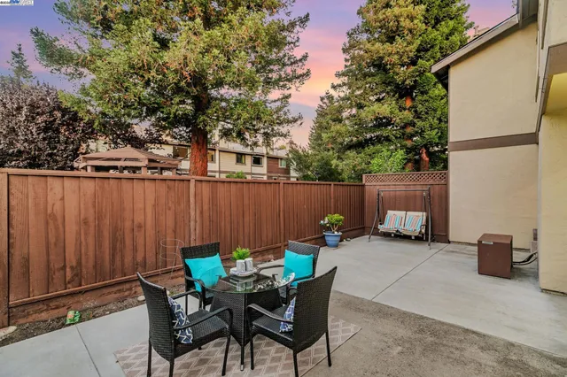a backyard of a house with table and chairs